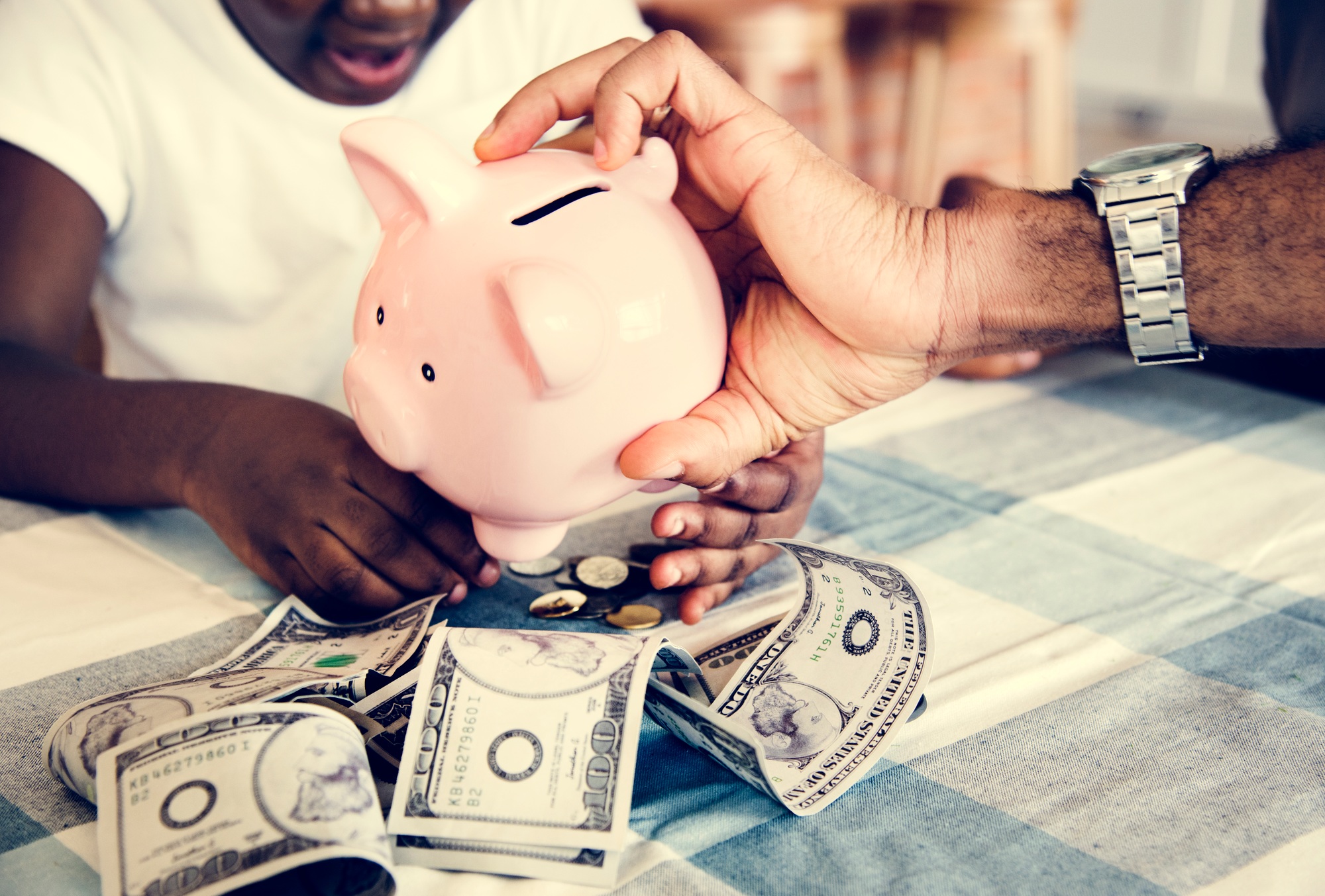 Dad and daughter saving money to piggy bank